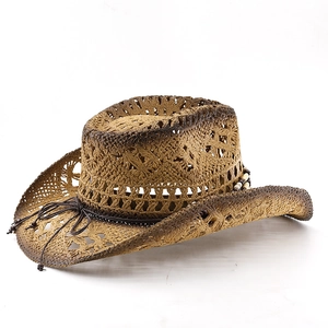 Close-up of Western straw cowboy hat featuring intricate hollow weave and beaded band