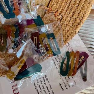 Jelly textured acrylic wave hair clips in assorted dark colors on rustic background