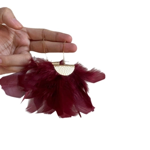 Vintage gold textured earrings with deep red feather tassels for a bohemian aesthetic