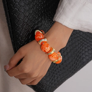Macro di bracciale retrò con grandi perle acriliche arancioni e distanziali dorati