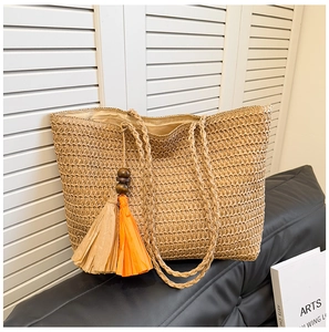 Detail of straw tote bag featuring colorful tassels and wooden bead top decoration