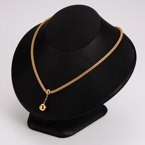 Golden stainless steel woven chain necklace with bead tassel pendant on a display model