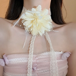 Detail of cream lace choker necklace with a large 3D flower, feathers, and pearls on a model
