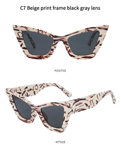 Detail view of cat eye sunglasses with beige printed frames and dark grey lenses