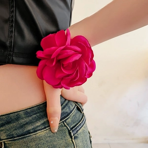Macro detail of large magenta silk rose floral necklace with layered satin petals for women