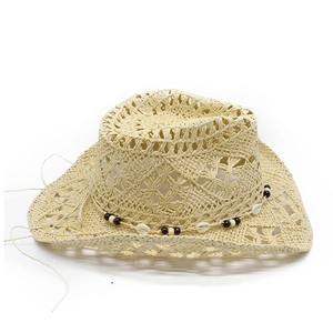 Detail of hollow-out straw cowboy hat featuring decorative dark wood beads and white shells