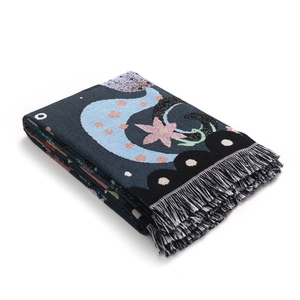 Detail of bohemian unicorn camping blanket showing woven moon patterns and black fringe