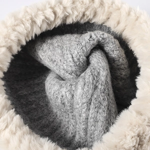 Close-up of winter knit bucket hat with warm grey lining and beige faux fur trim