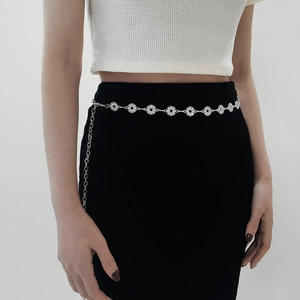 Detail of silver rhinestone waist chain on a black dress highlighting shimmering crystals