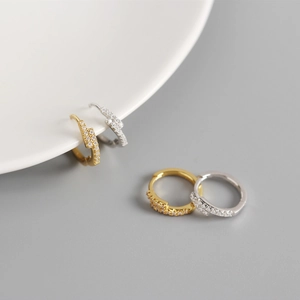 Detailed view of silver and gold lightning bolt earrings with micro-inlaid zircons