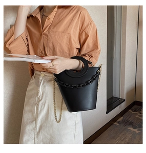 Detail of black PU leather bucket bag with gold chain strap and ring handle