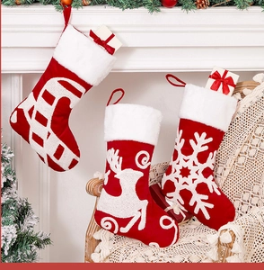 Close-up of three plush Christmas stockings with reindeer and snowflake embroidery details