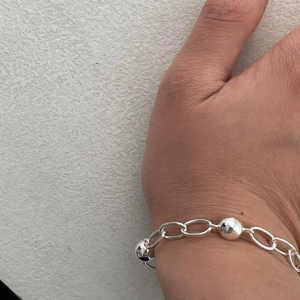 Detail of minimalist 925 sterling silver beaded chain bracelet worn on a female wrist