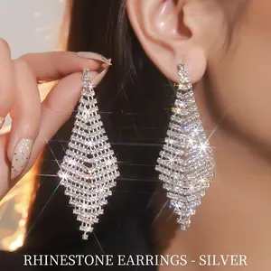Close-up of sparkling silver rhinestone tassel earrings with geometric diamond shapes