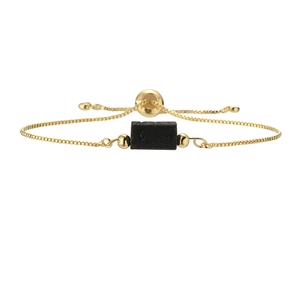 Detail of adjustable gold box chain bracelet featuring a black natural stone pendant
