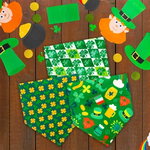 Detailed flat lay of three St. Patrick's Day themed pet bandanas on wood background