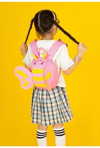 Pink cartoon bee backpack for toddlers with wings shown worn by a child on yellow background