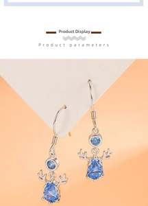 Macro view of silver reindeer earrings with sparkling blue teardrop gemstones and antlers