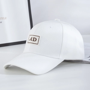 Close-up of a white cotton baseball cap showing side profile and AD letter embroidery