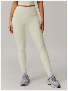 Close-up of high-waisted cream yoga leggings with functional side pockets and soft fabric