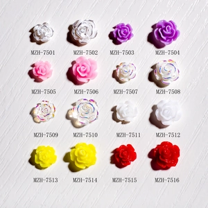 3D resin rose nail charms set in various colors and sizes on white wood background