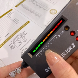 Diamond tester testing heart-shaped moissanite earrings with professional certificates