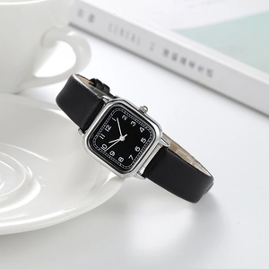 Montre carrée argentée chic avec bracelet en cuir noir et cadran dans un décor de vie