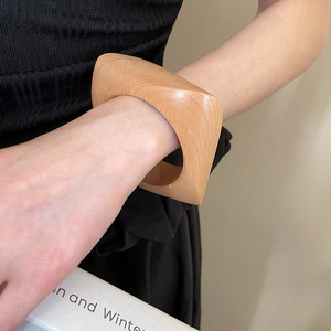 Vue détaillée du grain de bois clair sur un bracelet géométrique carré pour femmes