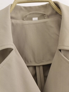 Detail of khaki trench coat collar showing twill fabric texture and stitching quality