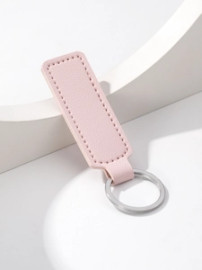 Detail of pink rectangular PU leather keychain with silver metal ring and stitching