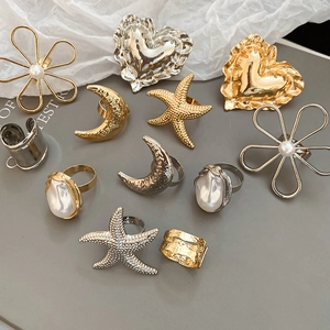Makroaufnahme verschiedener goldener und silberner Ringe mit Herz- und Blumenmotiven