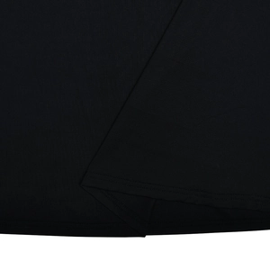 Gros plan de la texture du tissu noir montrant l'ourlet double épaisseur et les coutures