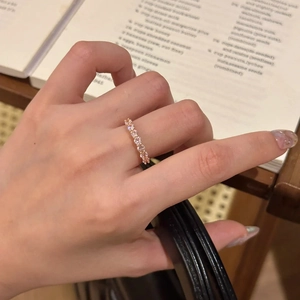 Close-up of a gold eternity ring with sparkling pink stones on a vintage background
