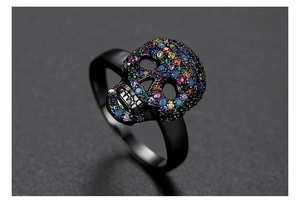Detailed close-up of a black punk skull ring with vibrant colorful pavé-set crystals