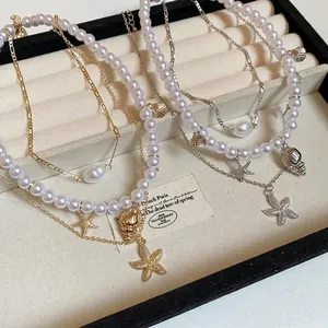 Gold and silver layered starfish shell pearl necklaces displayed in jewelry box
