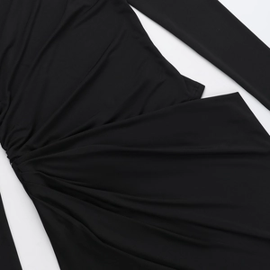 Close-up detail of black ruched stretch fabric texture on a long sleeve dress