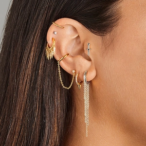 Detail of silver tassel chain earrings with zircon accents on a female model's ear