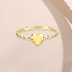 Elegant gold S925 sterling silver heart ring with side diamonds on beige texture