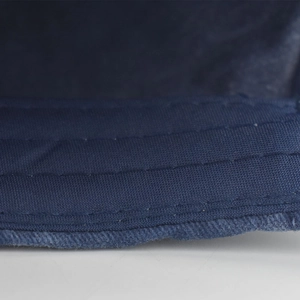 Detailed macro view of reinforced triple stitching on navy cotton baseball cap brim