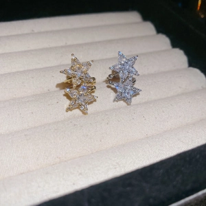 Detailed macro of gold and silver double-layered star ear cuffs with zircon pavé