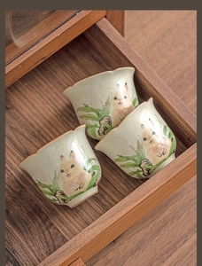 Detailed top view of ceramic tea cups with rabbit motifs and ice crackle glaze inside drawer