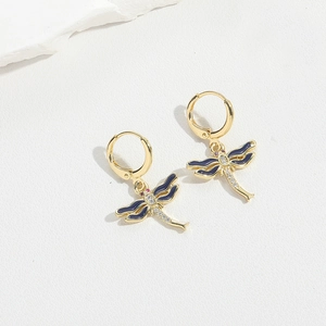Detailed view of dragonfly earrings with blue enamel wings and inlaid cubic zirconia