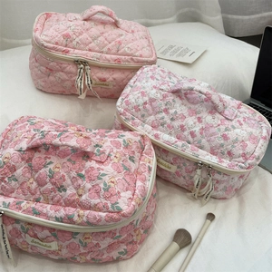 Detailed view of three pink floral quilted cotton cosmetic bags with zip and ribbon