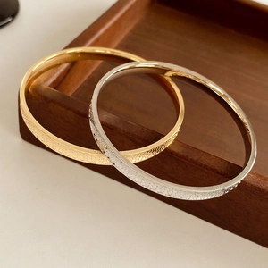 Minimalist gold and silver circular textured bracelets with honeycomb engraved pattern