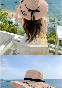 Detail of straw sun hat featuring Hello Sunshine embroidery and black ribbon bow detail