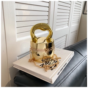 Detailed view of luxury gold cylindrical acrylic clutch bag with a unique curved handle