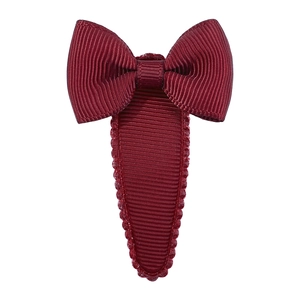 Detailed view of dark red grosgrain ribbon bow hair clip with textured drop-shaped base