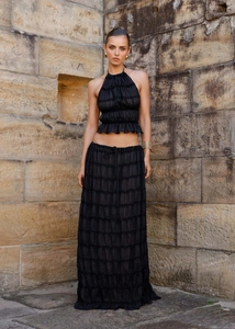 Detail showing the pleated texture of the black halter crop top and long skirt set