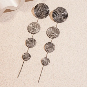 Détail de boucles d'oreilles pendantes gris fusil avec texture spirale et tiges en métal