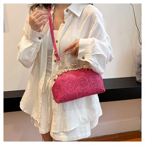 Detail of rose red vintage shell bag featuring 3D floral embossing and gold clasp